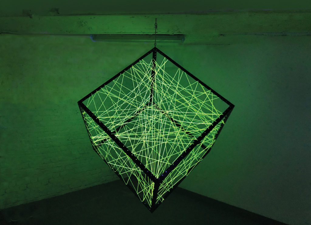 Johannes Pfeiffer, Un metre cube de communication, 2017. Profilo di ferro, filo elastico fluorescente, lampade di Wood.